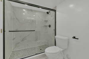 Bathroom with a shower with shower door and toilet