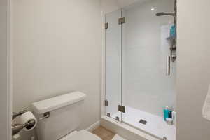 Bathroom with toilet and a shower with shower door