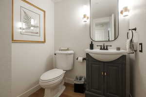 Bathroom featuring vanity, wood-type flooring, and toilet