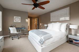 Carpeted bedroom featuring ceiling fan