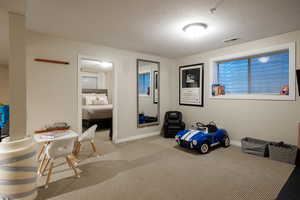 Interior space with a textured ceiling and carpet