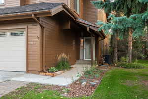 View of exterior entry with cooling unit and a garage