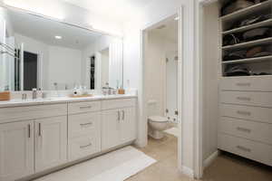 Bathroom with tile patterned flooring, vanity, a shower with shower door, and toilet