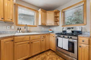 Kitchen with gas range, sink, and light stone counters