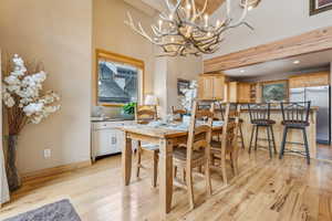 Dining room with a chandelier, beam ceiling, and light hardwood / wood-style flooring