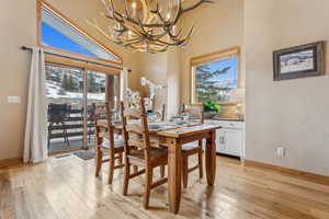 Dining room with a notable chandelier, a healthy amount of sunlight, and light wood-type flooring