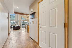 Corridor featuring an inviting chandelier and beam ceiling