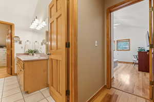 Bathroom with vaulted ceiling, vanity, hardwood / wood-style floors, and a bathtub