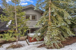 View of snow covered exterior with a hot tub