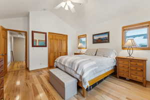 Bedroom featuring lofted ceiling, light hardwood / wood-style floors, a closet, and ceiling fan