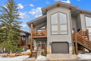 View of front facade featuring a garage and a balcony