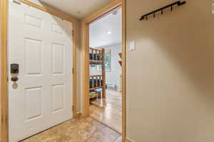 Corridor with baseboard heating and light tile patterned flooring