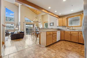 Kitchen featuring pendant lighting, sink, a kitchen bar, kitchen peninsula, and beamed ceiling