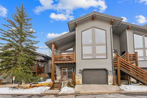 View of front of house with a garage and a balcony