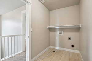 Laundry room with electric dryer hookup, washer hookup, light hardwood / wood-style flooring, and a textured ceiling