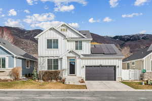 View of front of property with a mountain view and solar panels