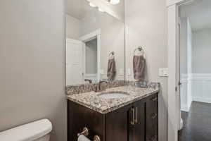 Bathroom featuring vanity, wood-type flooring, and toilet