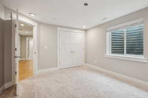 Unfurnished bedroom with light colored carpet and a closet