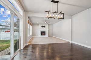 Unfurnished living room with dark wood-type flooring and ceiling fan