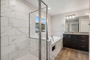 Bathroom featuring vanity, separate shower and tub, and hardwood / wood-style floors