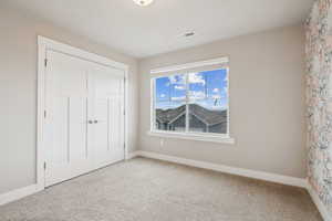 Unfurnished bedroom featuring a closet and carpet