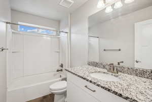 Full bathroom with shower / tub combination, vanity, toilet, and wood-type flooring