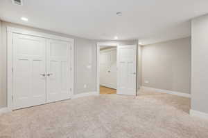 Unfurnished bedroom featuring light colored carpet and a closet