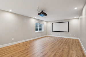 Home theater with light hardwood / wood-style floors