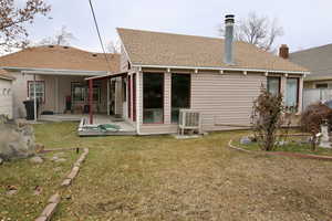 Back of house with a wooden deck and a yard