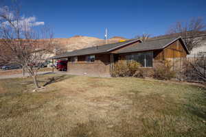 Exterior space featuring a carport, a yard, and a mountain view