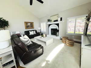 Living room with ceiling fan and high vaulted ceiling