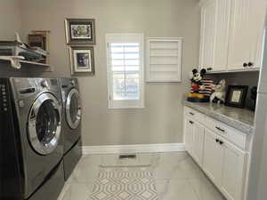 Clothes washing area with cabinets and washing machine and clothes dryer