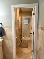 Bathroom with walk in shower, vanity, and tile walls