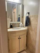 Bathroom featuring vanity and tile walls