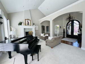 Interior space featuring french doors, high vaulted ceiling, carpet, and a tile fireplace