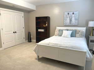 Bedroom featuring light colored carpet and a closet