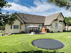 Back of property with a yard, a gazebo, a patio area, and central AC unit