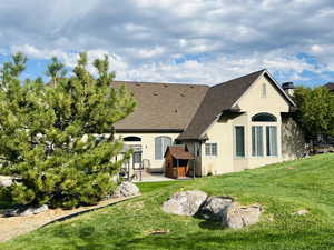 Rear view of property featuring a patio area and a lawn