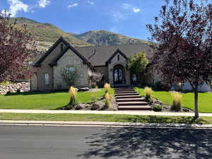 View of front of property with a mountain view and a front yard