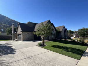 View of front facade with a garage, a mountain view, and a front yard