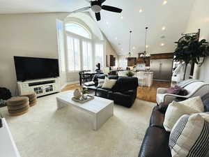 Living room with ceiling fan, light hardwood / wood-style floors, and high vaulted ceiling