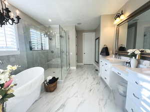 Bathroom featuring vanity, separate shower and tub, a notable chandelier, and a textured ceiling