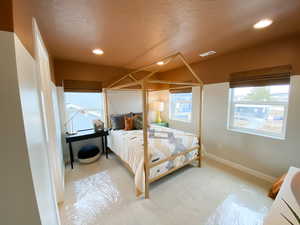 Carpeted bedroom with natural light and walk in closet.