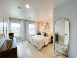 Carpeted bedroom with natural light and walk in closet.