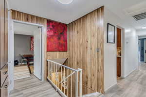 Corridor featuring wooden walls and light hardwood / wood-style flooring