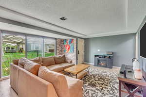 Living room featuring a tray ceiling, light hardwood / wood-style floors, and a textured ceiling