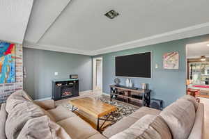 Living room with ceiling fan, hardwood / wood-style flooring, and a textured ceiling