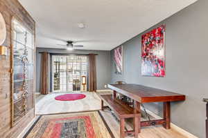 Dining area featuring ceiling fan, a textured ceiling, and light hardwood / wood-style flooring