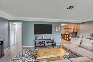 Living room featuring a textured ceiling and light hardwood / wood-style flooring