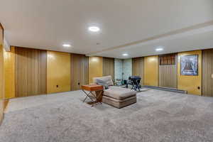 Unfurnished room featuring a baseboard heating unit and carpet flooring